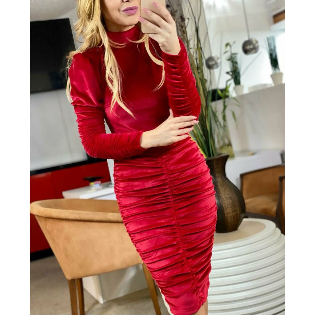 a woman in a red dress standing in a kitchen