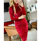 a woman in a red dress standing in a kitchen 